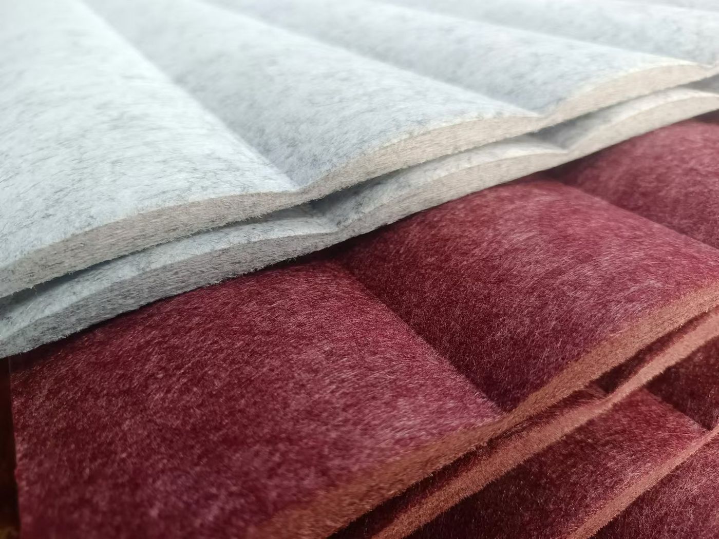 Detalle de panel ondulado acolchado en gris y burdeos