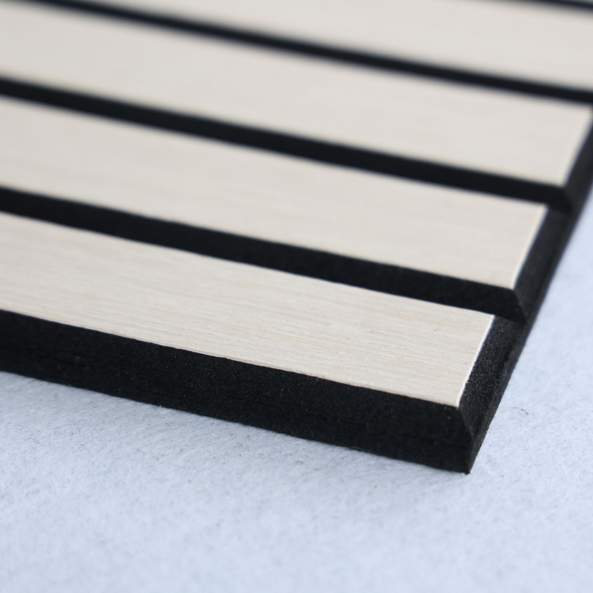 Detalle de listones de chapa de roble sobre panel PET negro